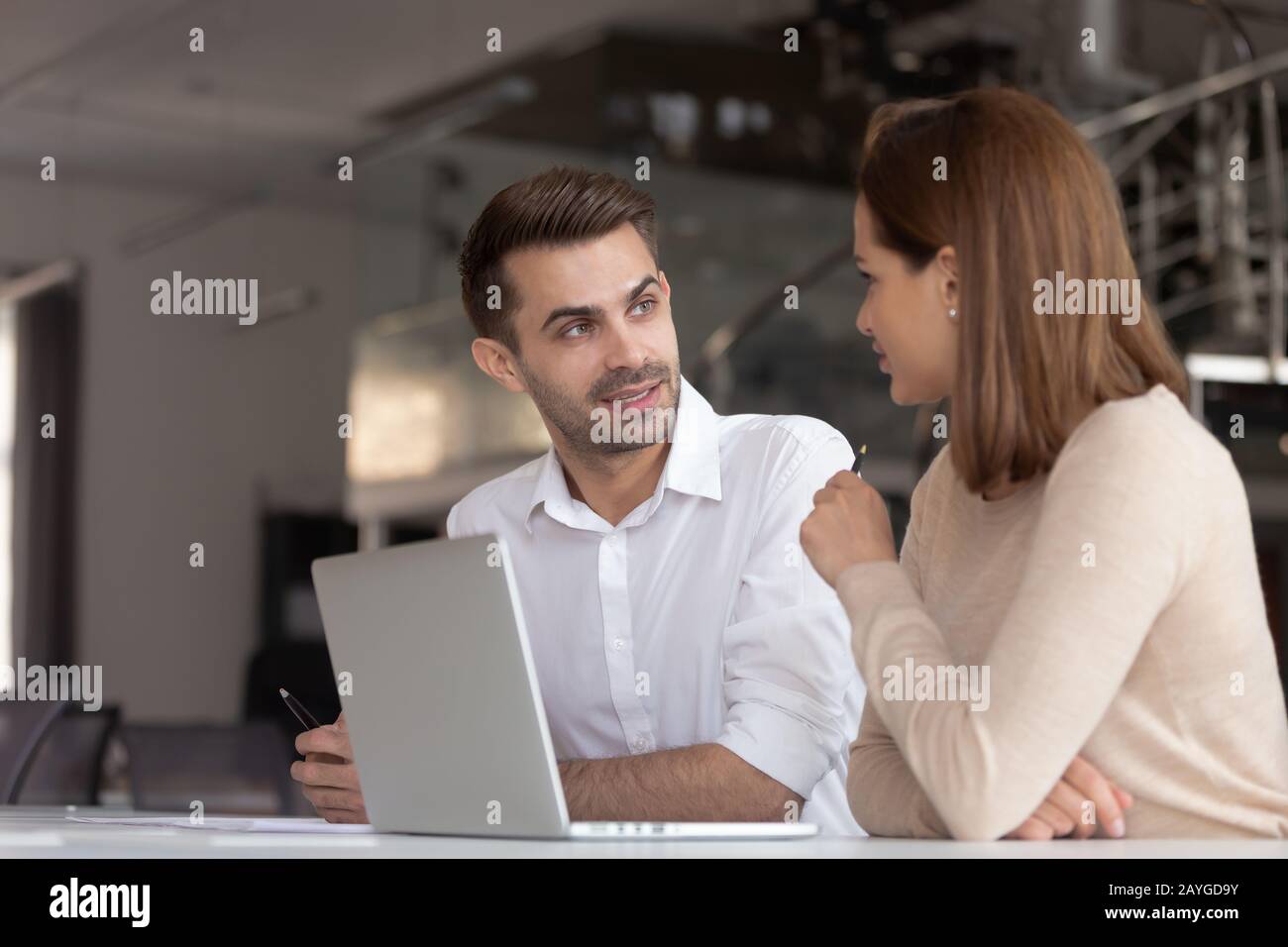 Focused diverse employees talk working at laptop together Stock Photo ...