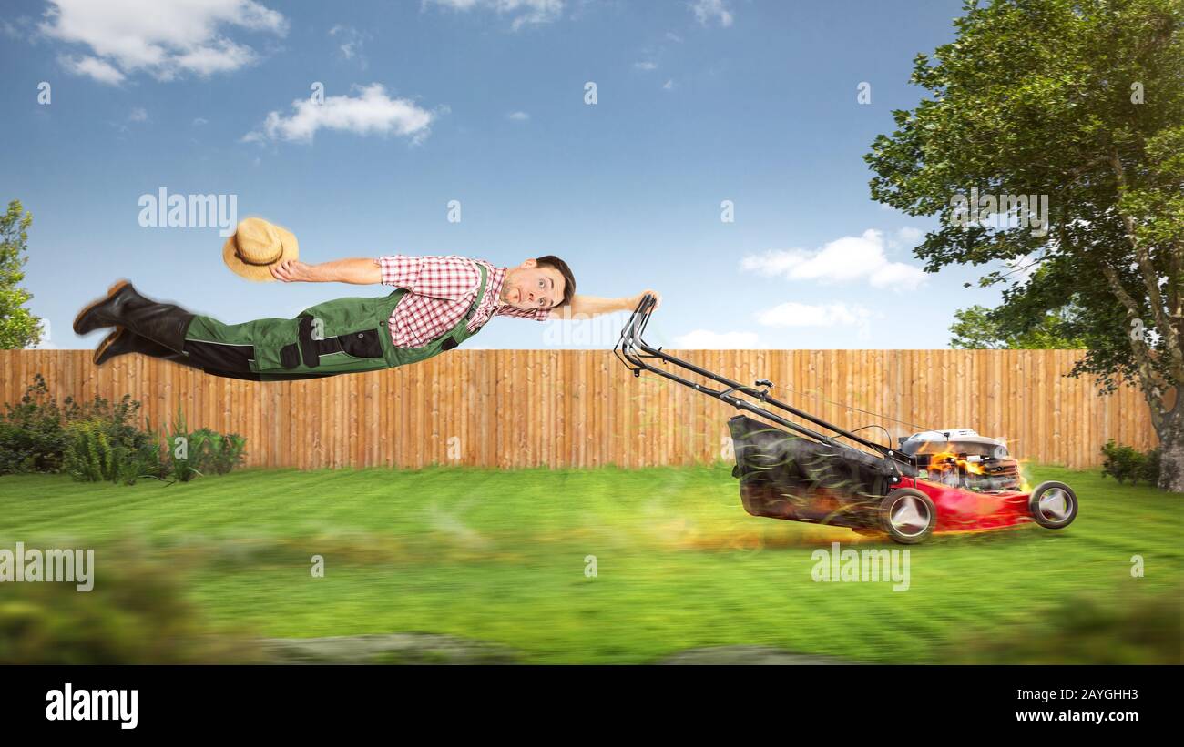 Funny gardener being pulled through the garden by a lawn mower Stock