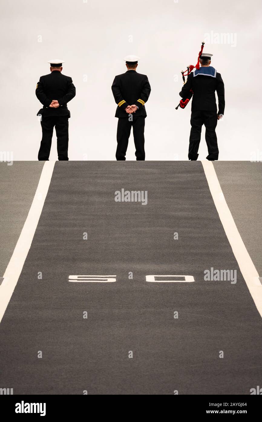 Sailors man the rails on the launch ramp of the Royal Navy's aircraft ...