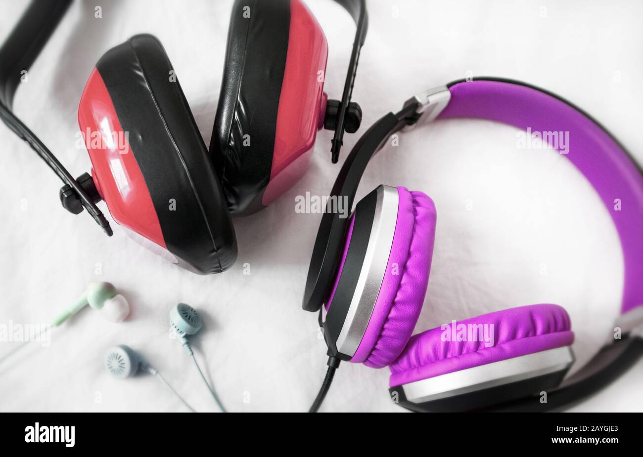 Noise canceler, headphones and earphones on a clear surface. Stock Photo