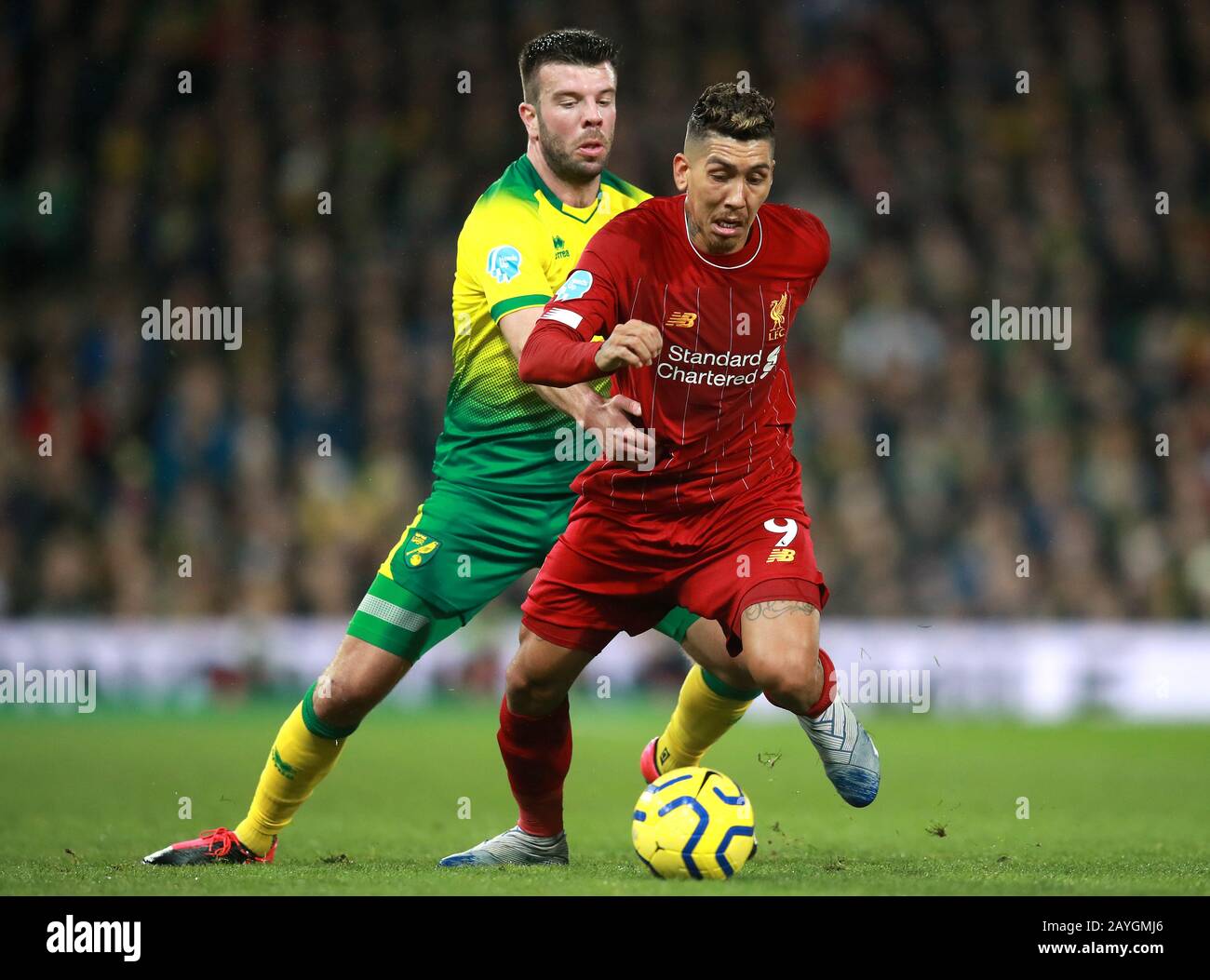 Norwich City's Grant Hanley (left) and Liverpool's Roberto Firmino battle for the ball during the Premier League match at Carrow Road, Norwich. Stock Photo