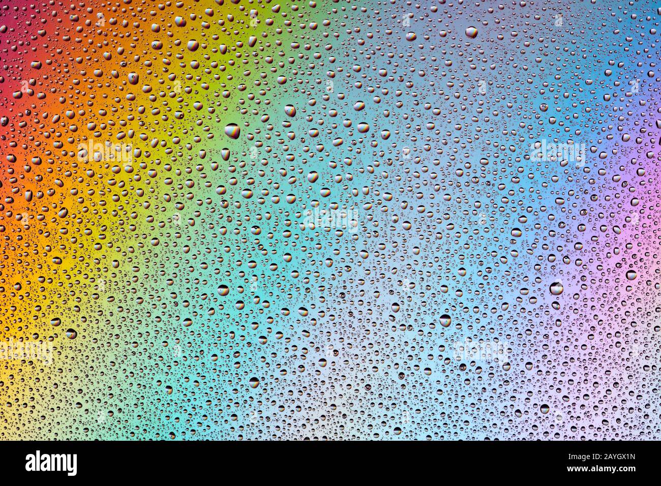 Water Drops on multi-colored rainbow Background. Stock Photo