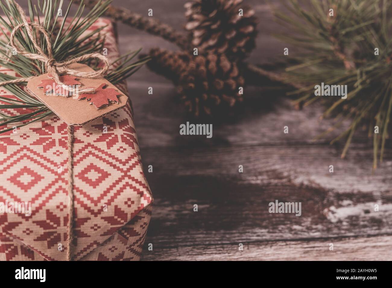 Closeup of a Christmas present with creative handmade decorative rustic diy gift wrapped in red retro wrapping paper with natural vintage twine Stock Photo