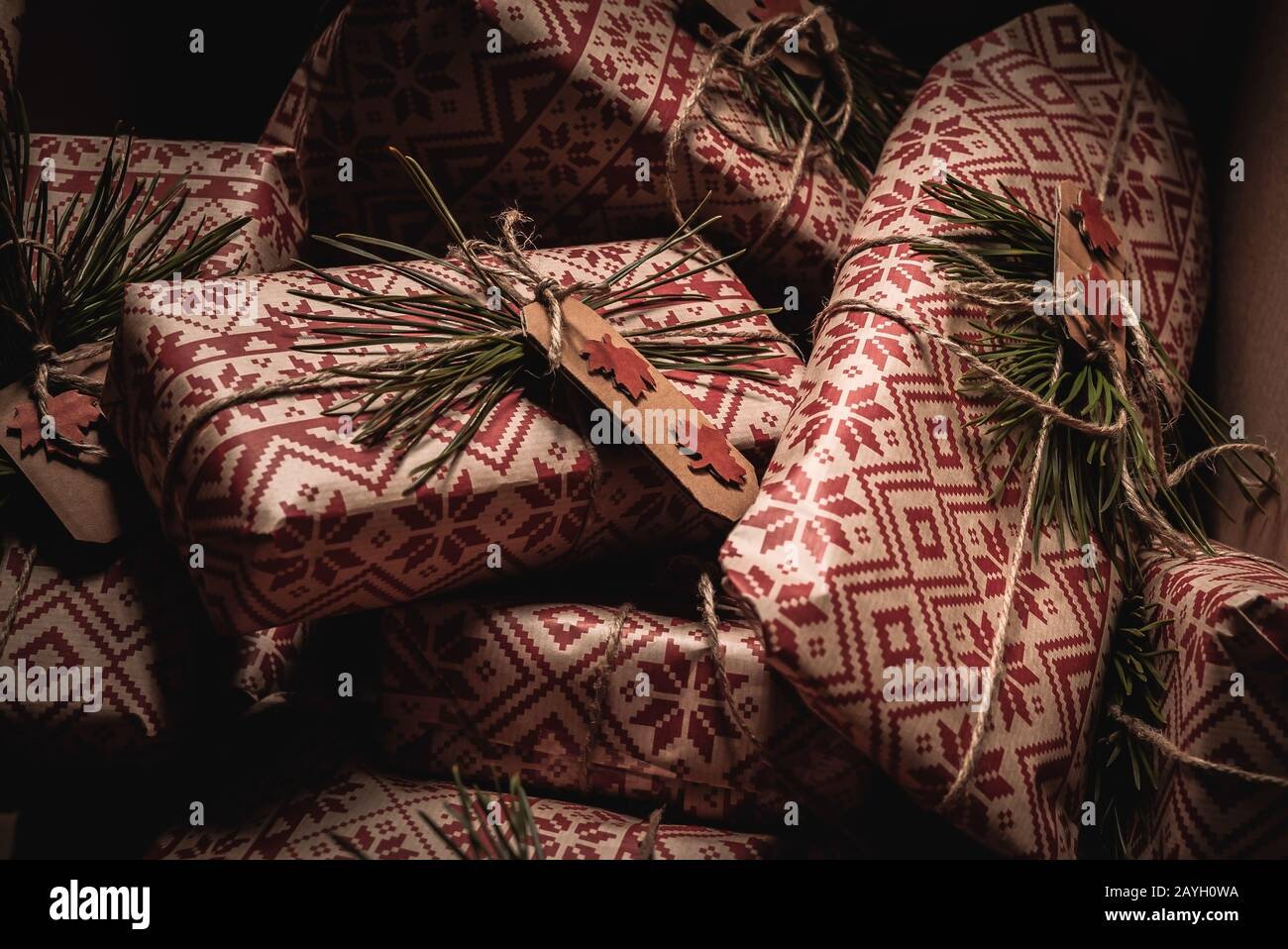 Many christmas presents piled up in a box with creative handmade decorative rustic diy gift wrapped in natural vintage retro wrapping paper Stock Photo