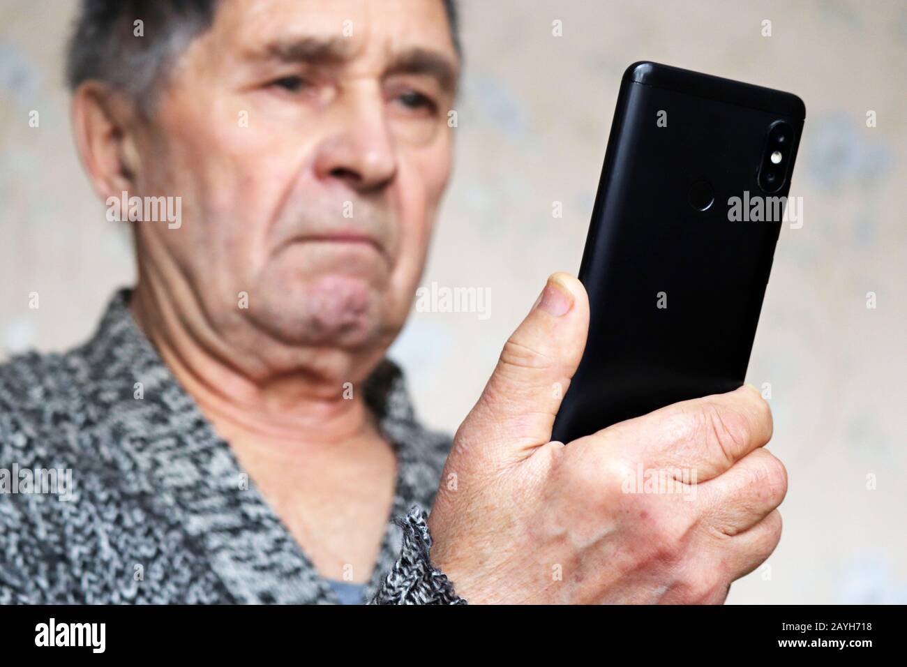 Elderly man using smartphone, mobile phone in male hands close up. Concept of online communication in retirement, sms, social media Stock Photo