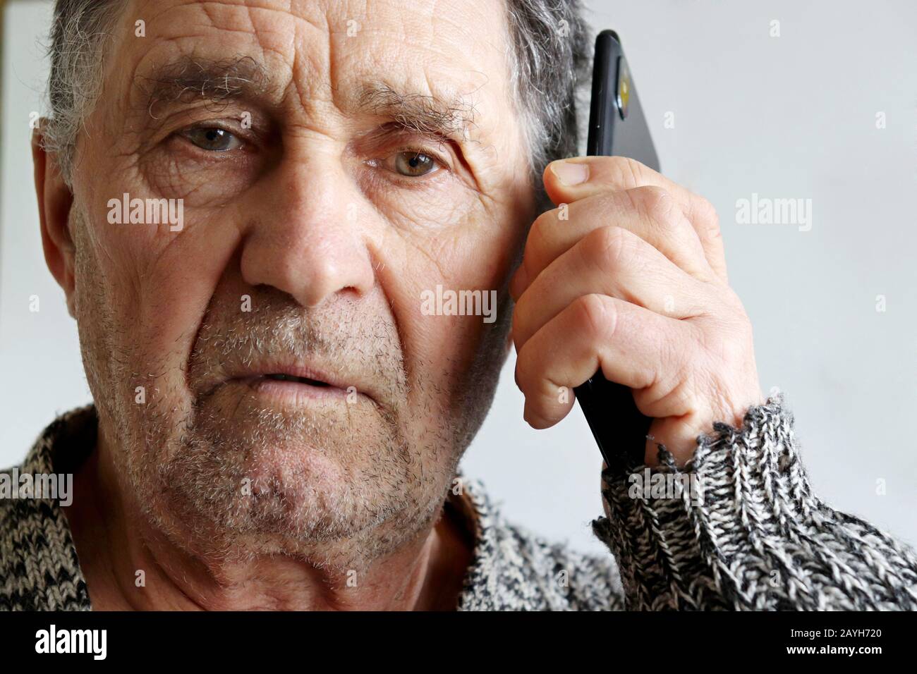 Portrait of elderly man talking on mobile phone, smartphone in male hands close up. Concept of communication in retirement Stock Photo