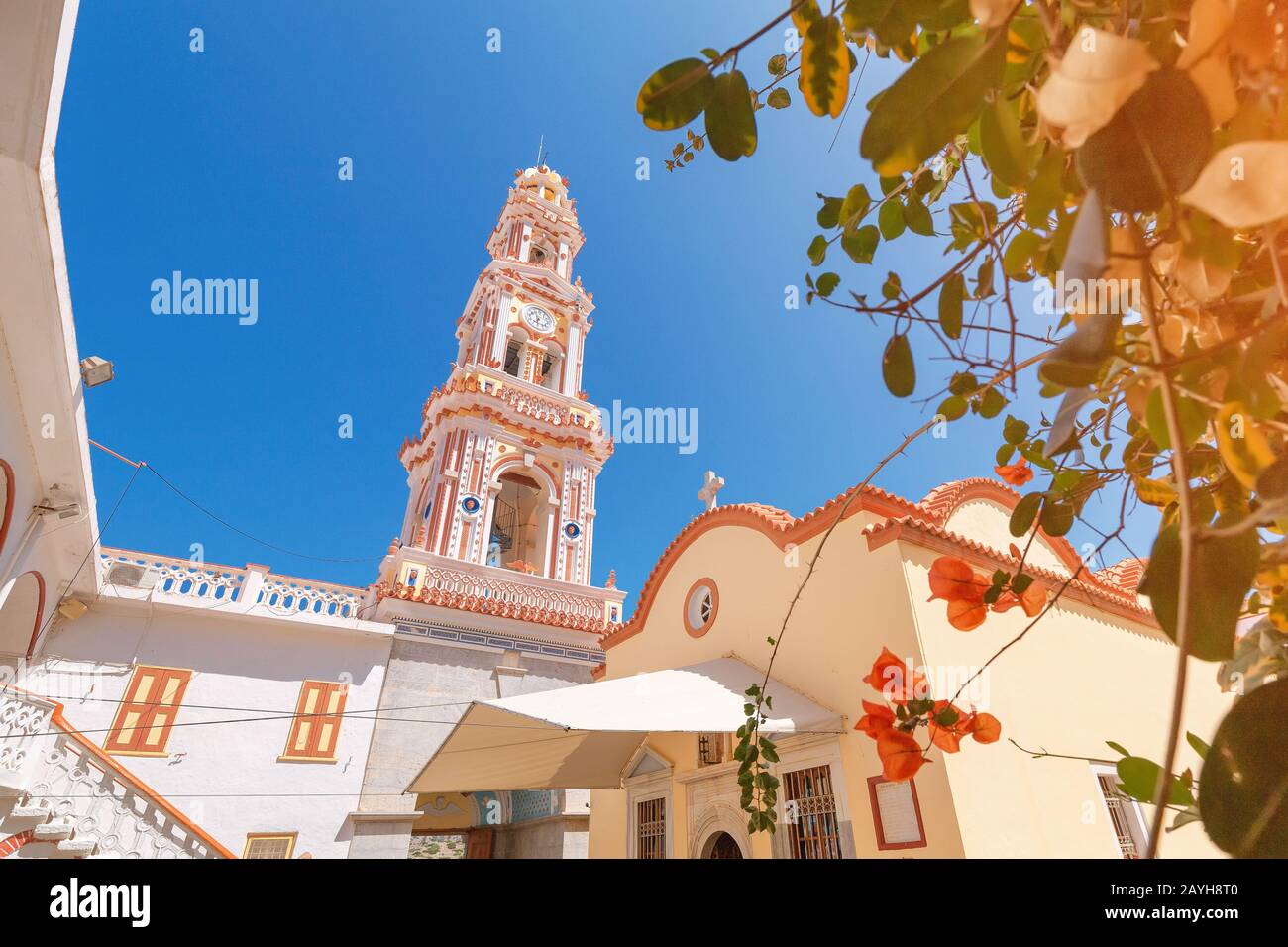 Tourists visiting famous monastery Panormitis on the island of Symi, Greece. Dodecanese sightseeing and mediterranean sea travel concept Stock Photo