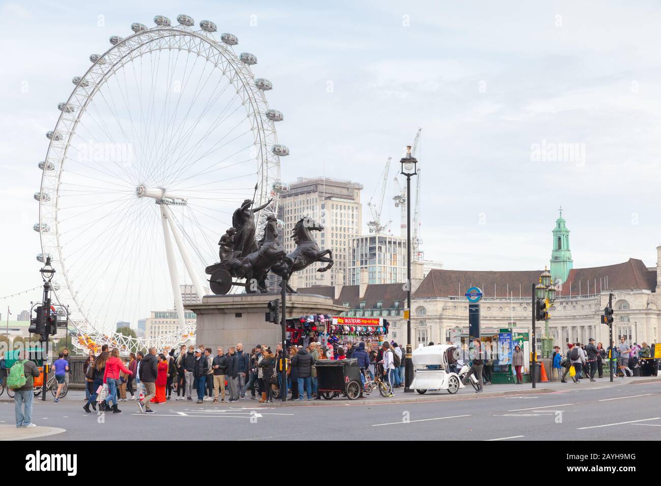 London, United Kingdom - October 31, 2017: London view with tourists walk near Boadicea and Her Daughters bronze sculptural group and London Eye giant Stock Photo