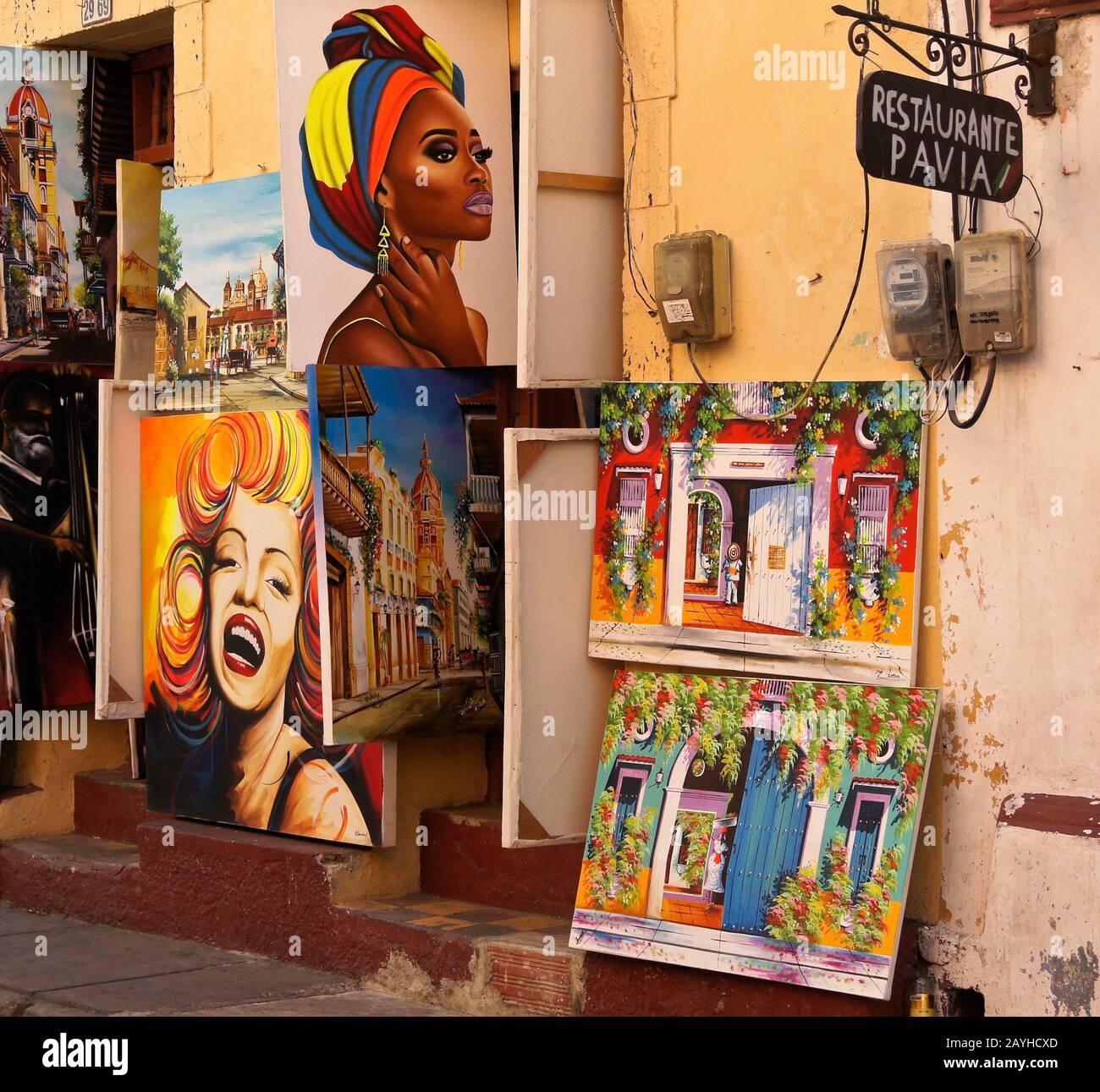 Colorful paintings displayed for sale outside an art gallery and restaurant in Getsemani, Cartagena, Colombia Stock Photo