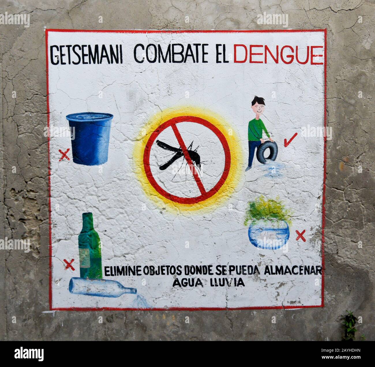 Information (in Spanish) painted on an exterior wall encourages eliminating objects which hold standing water and attract mosquitoes that cause dengue Stock Photo