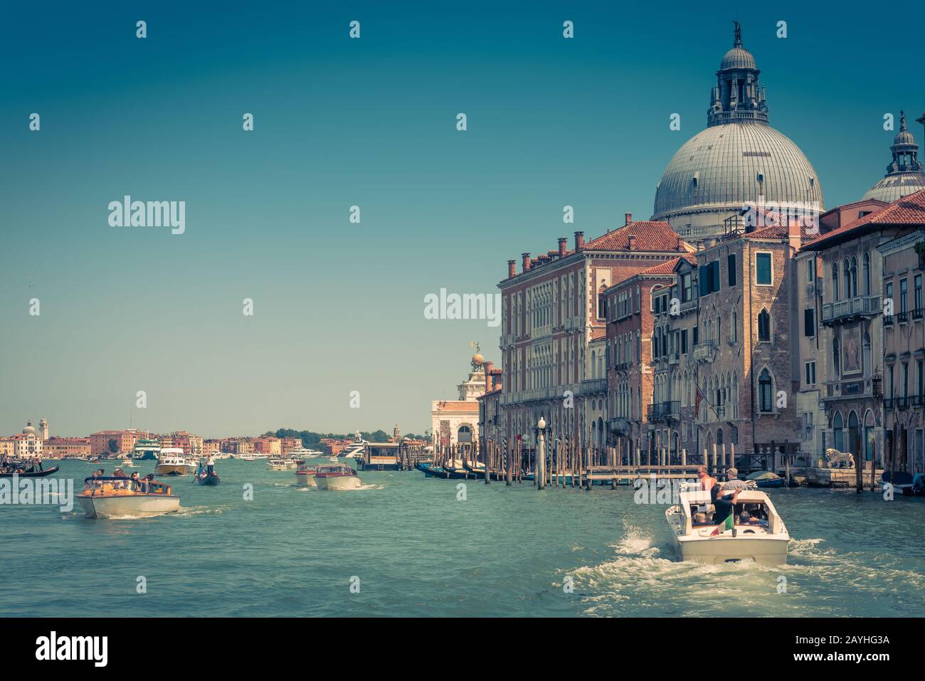 Water taxis and other boats are sailing along the Grand Canal in Venice, Italy. Motor boats are the main transport in Venice. Stock Photo