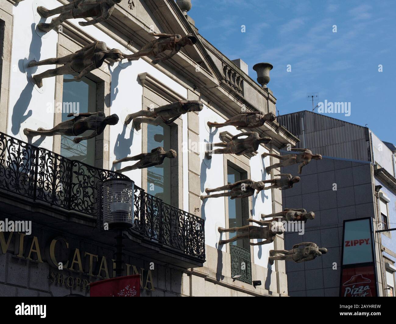 Artwork bronze people walking on the facade of the luxury Via Catarina
