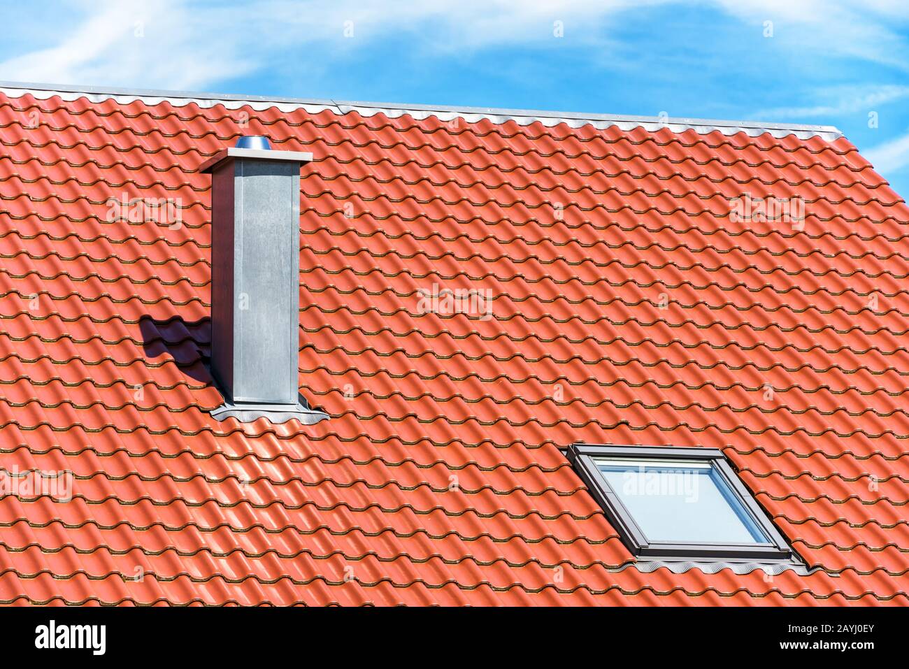 Chimney and window on clean roof of residential house. Steel home chimney close-up in summer. Modern air vent system on rooftop. Metal chimney pipe on Stock Photo