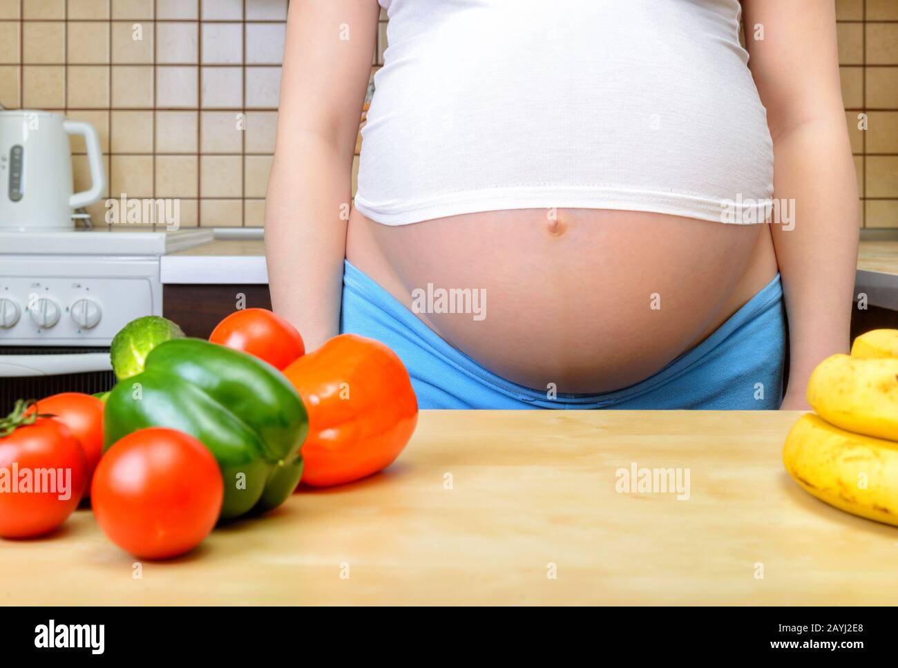 Pregnant woman with fresh vegetables in the kitchen Stock Photo - Alamy