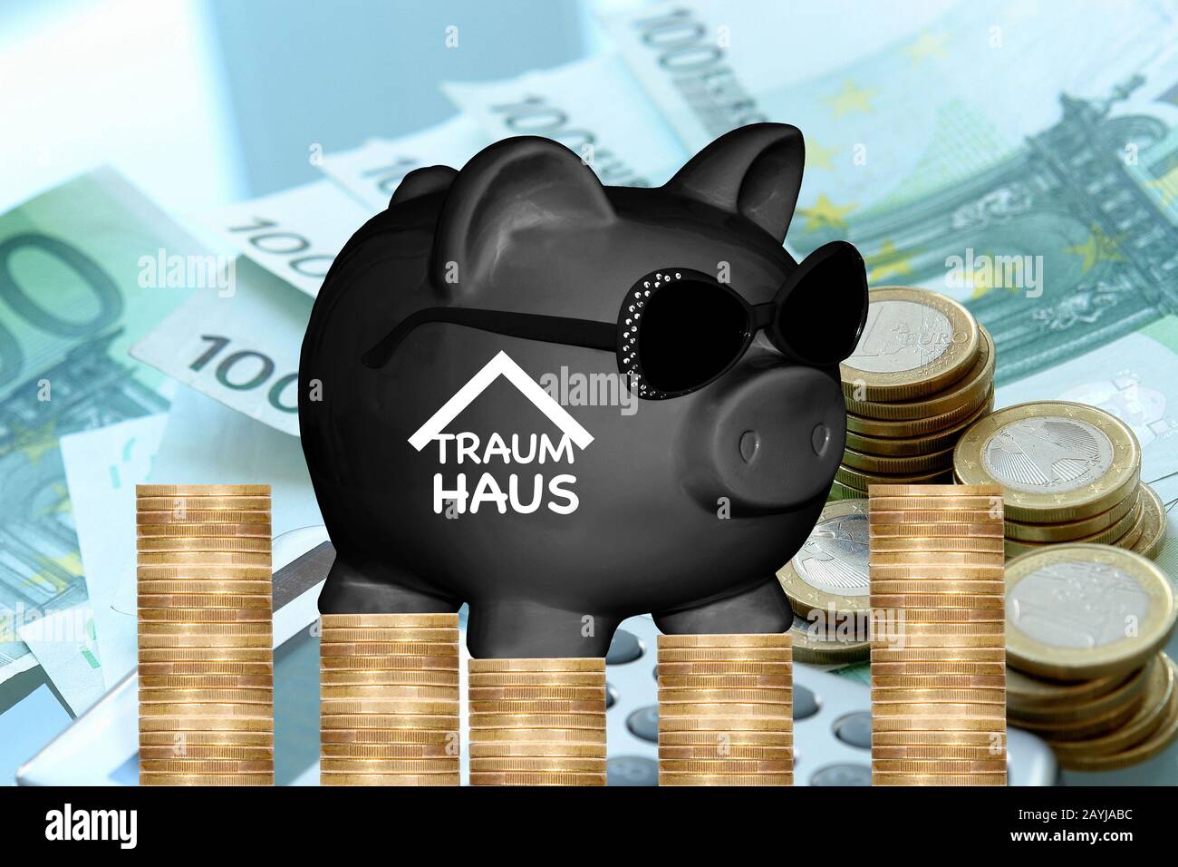 black piggy bank with sun glasses with lettering Traumhaus, dream house, coins and banknotes in background, composing Stock Photo