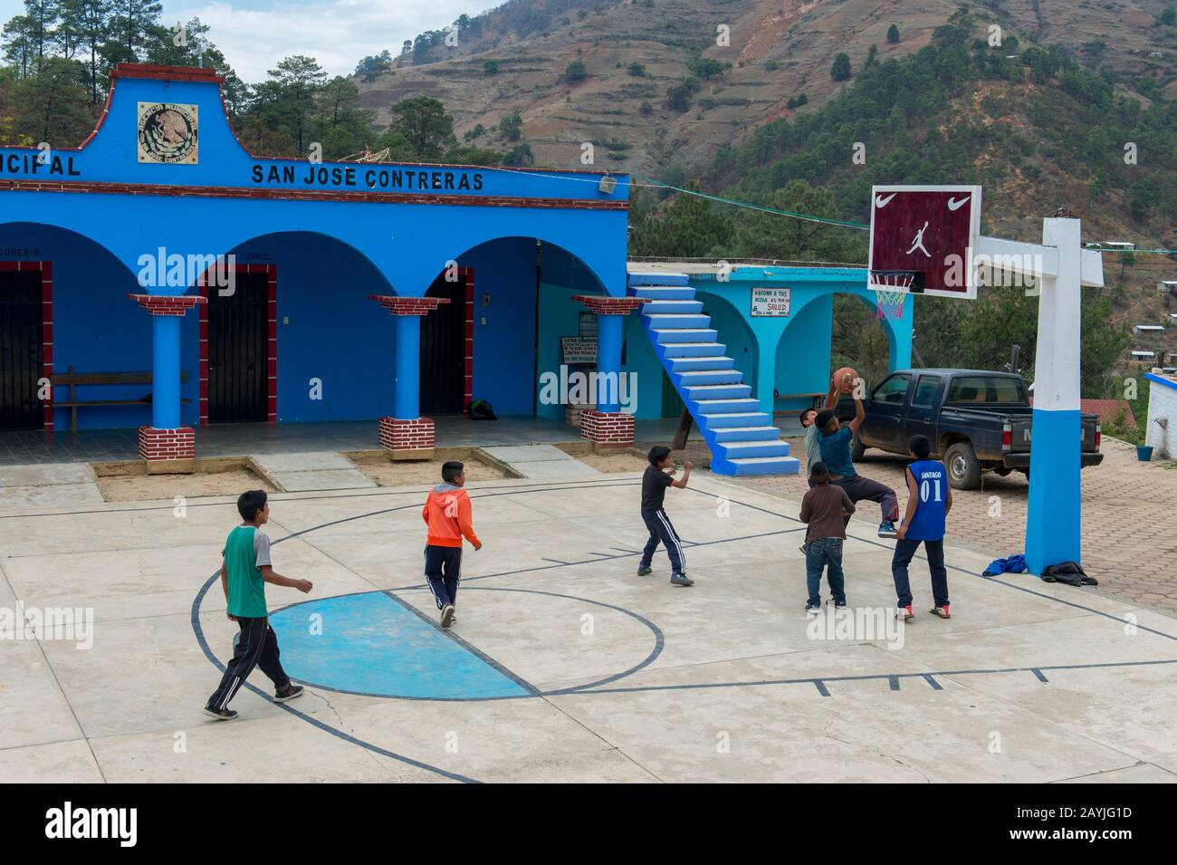 Local people playing basketball on the zocalo (main square) in the Mixtec village of San Juan Contreras near Oaxaca, Mexico. Stock Photo