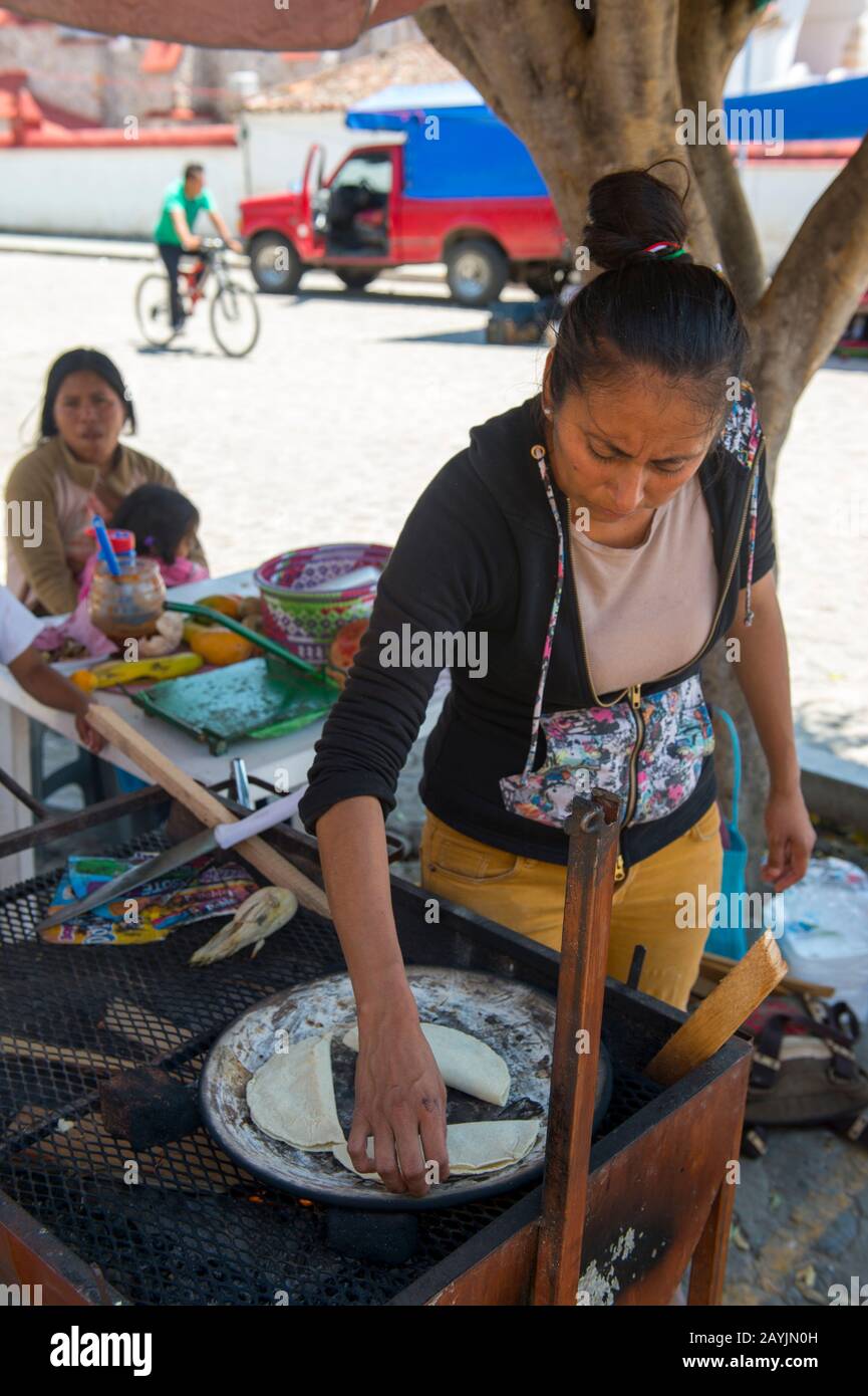 A street scene with a woman cooking street food in Teotitlan del Valle, a small town in the Valles Centrales Region near Oaxaca, southern Mexico. Stock Photo