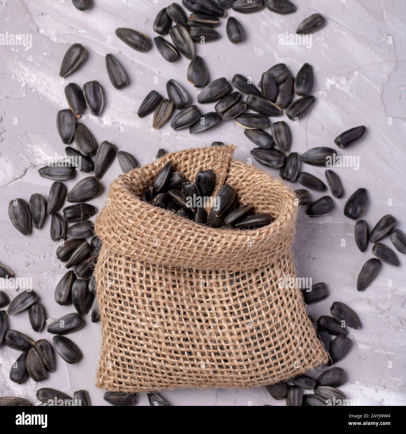 Burlap sack with black sunflower seeds, vertical photo Stock Photo