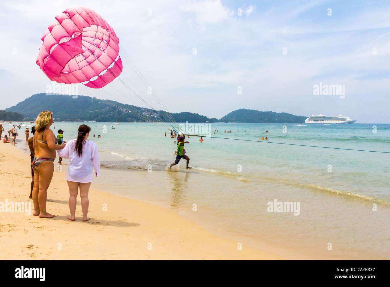 Patong, Phuket, Thailand - November 11th 2017: Parasailing off the beach. This is a popular water sport activity with tourists. Stock Photo
