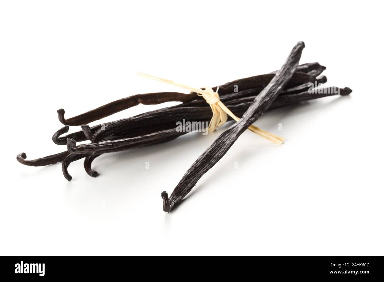 Bundle of tied, dried bourbon vanilla beans or pods over white background - selective focus Stock Photo