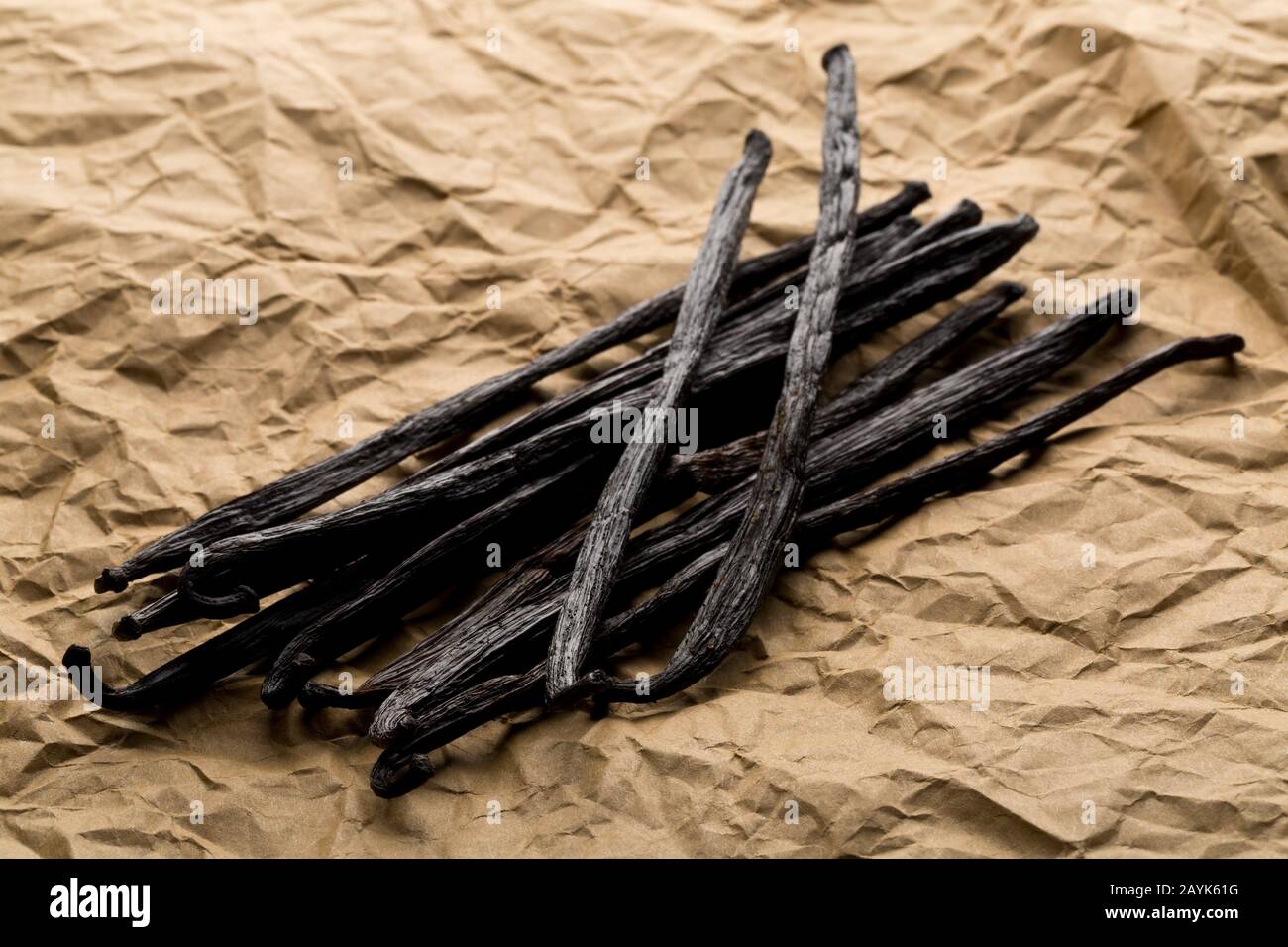 Bundle of dried bourbon vanilla beans or pods on brown packing paper flat lay top view from above Stock Photo
