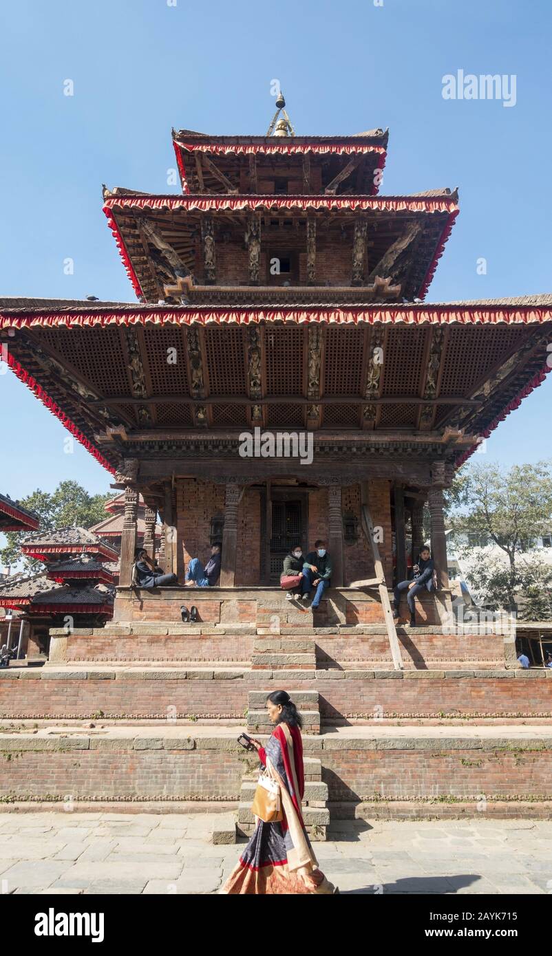Nepalese People Sitting and Passing by one of several Temples at Durbar Square, Famous Old Royal