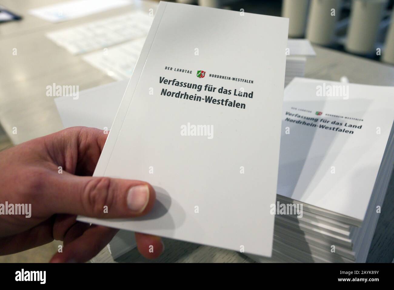 14 February 2020, North Rhine-Westphalia, Duesseldorf: A member of the state parliament holds a state constitution up to the camera. A pocket book with symbolic value: This year, the North Rhine-Westphalian state parliament will give all pupils who visit the parliament a compact edition of the state constitution. Around 35,000 young people visit the Landtag every year. According to a speaker of the state parliament, the occasion for the action is the 70th anniversary of the constitution. (to dpa: 'State parliament wants to distribute state constitutions to 35 000 pupils') Photo: Federico Gamba Stock Photo