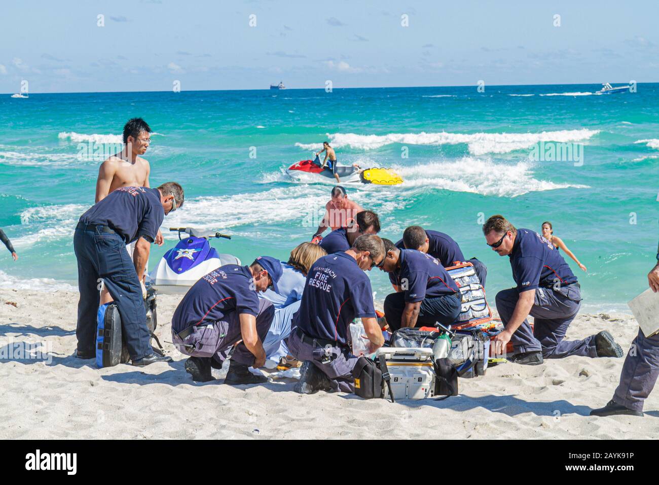 Miami Beach Florida,Atlantic Ocean water,fire rescue,emergency,applying CPR cardiopulmonary resuscitation,near drowning victim rough surf rip currents Stock Photo