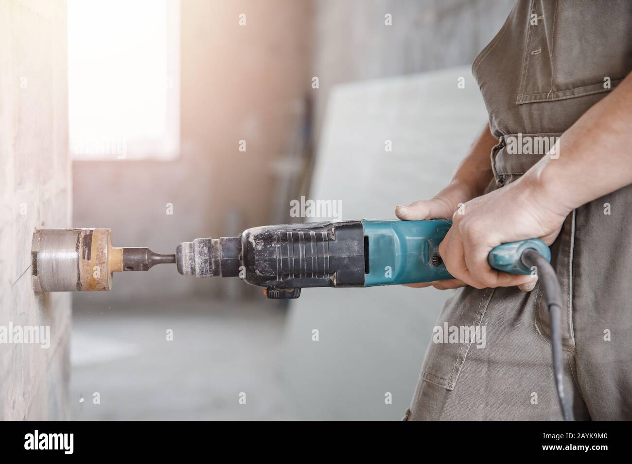 Builder man cutting electrical chase in concrete wall with hammer drill  diamond crown Stock Photo - Alamy