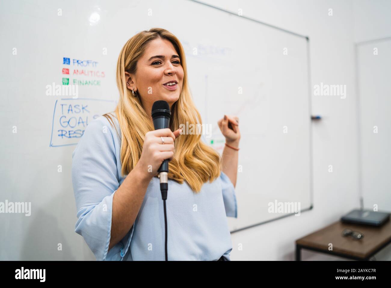 Friendly business woman explaining plan of work and answering questions on a work conference. Business concept. Stock Photo