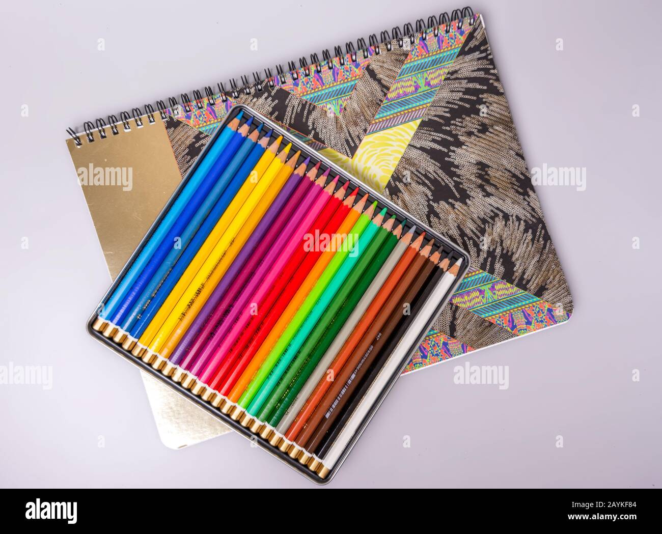 A box with sharpened multi-colored pencils lies on a sketchbook. Items for  creativity Stock Photo - Alamy
