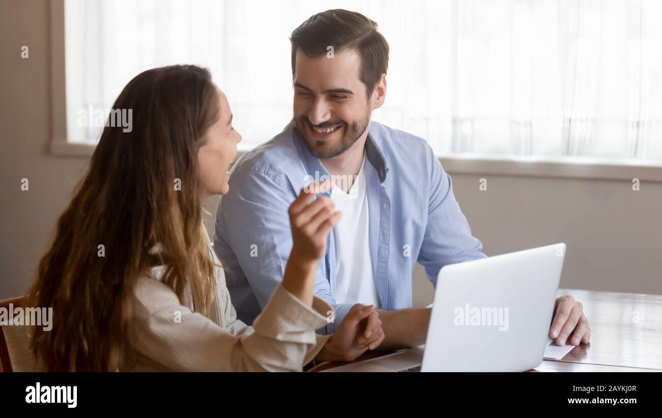 Happy millennial couple have fun using laptop Stock Photo