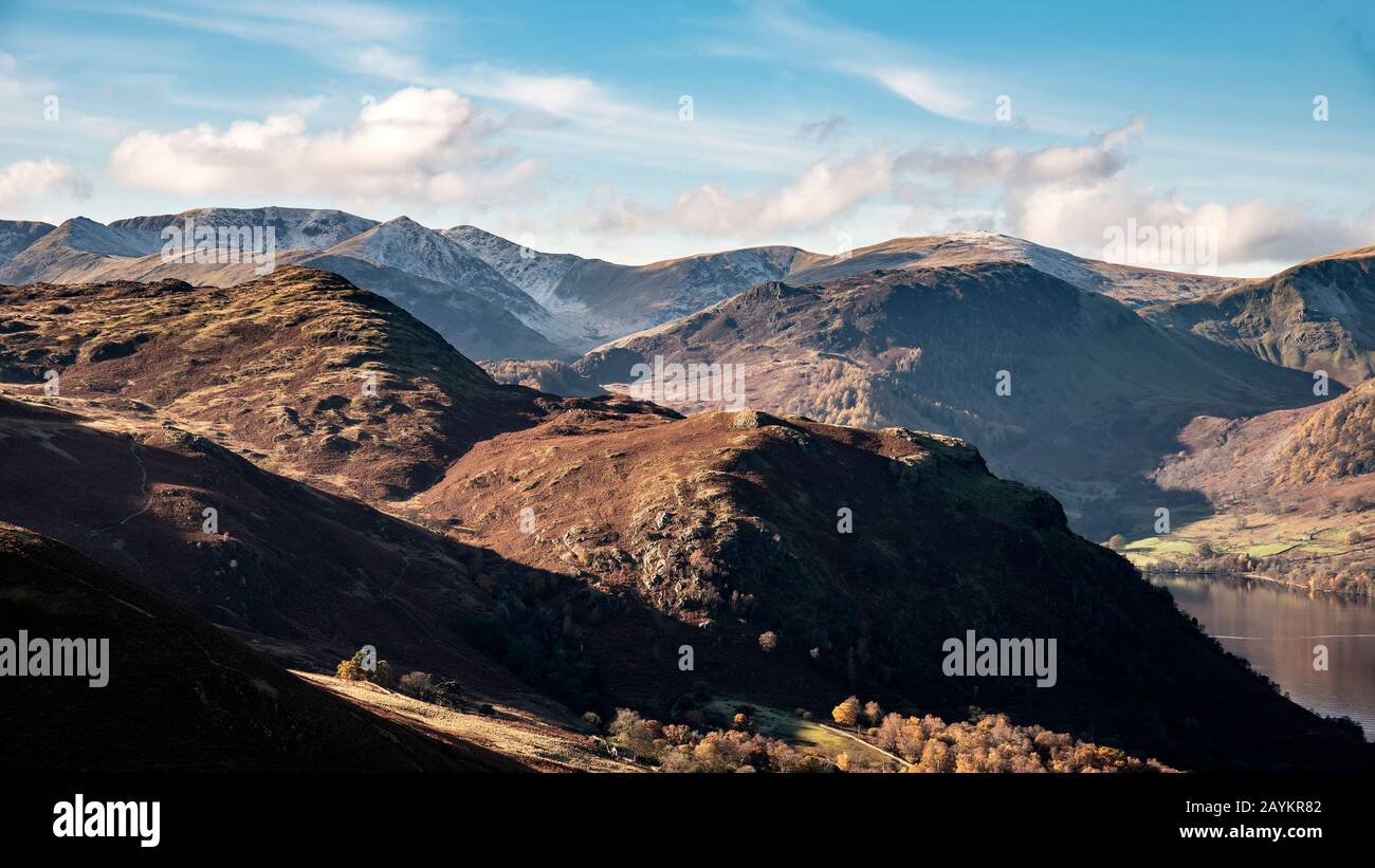 Epic Autumn Fall landscape of mountains and hills viewed from Hallin Fell on a crisp cold morning with stunning sunlgiht hitting the slopes Stock Photo