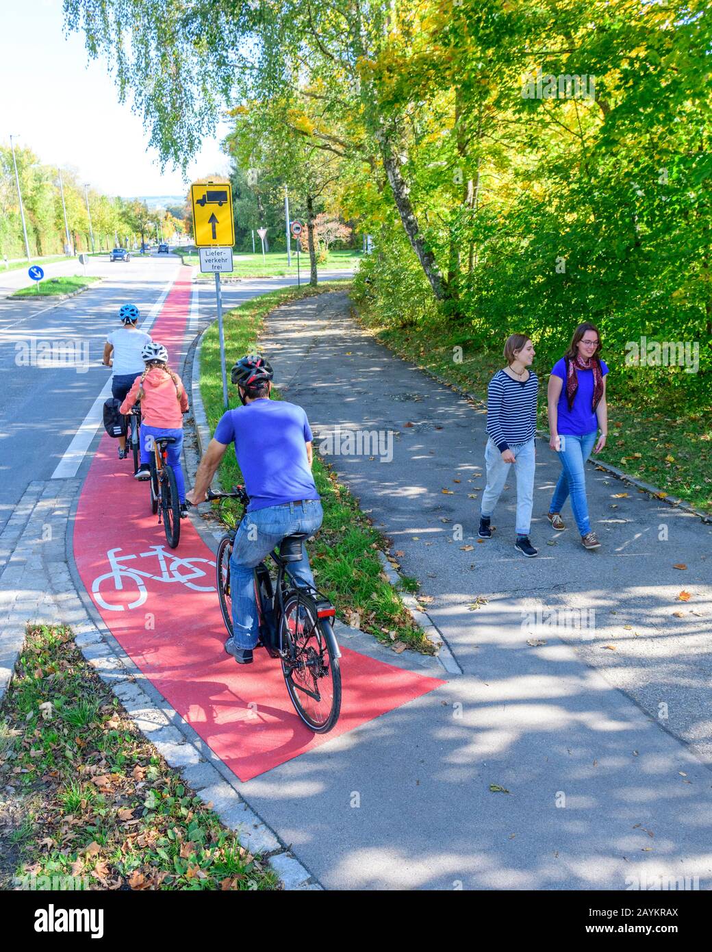 Cyclists changing from the cycle path to a combined cycling road and footpath with pedestrians Stock Photo