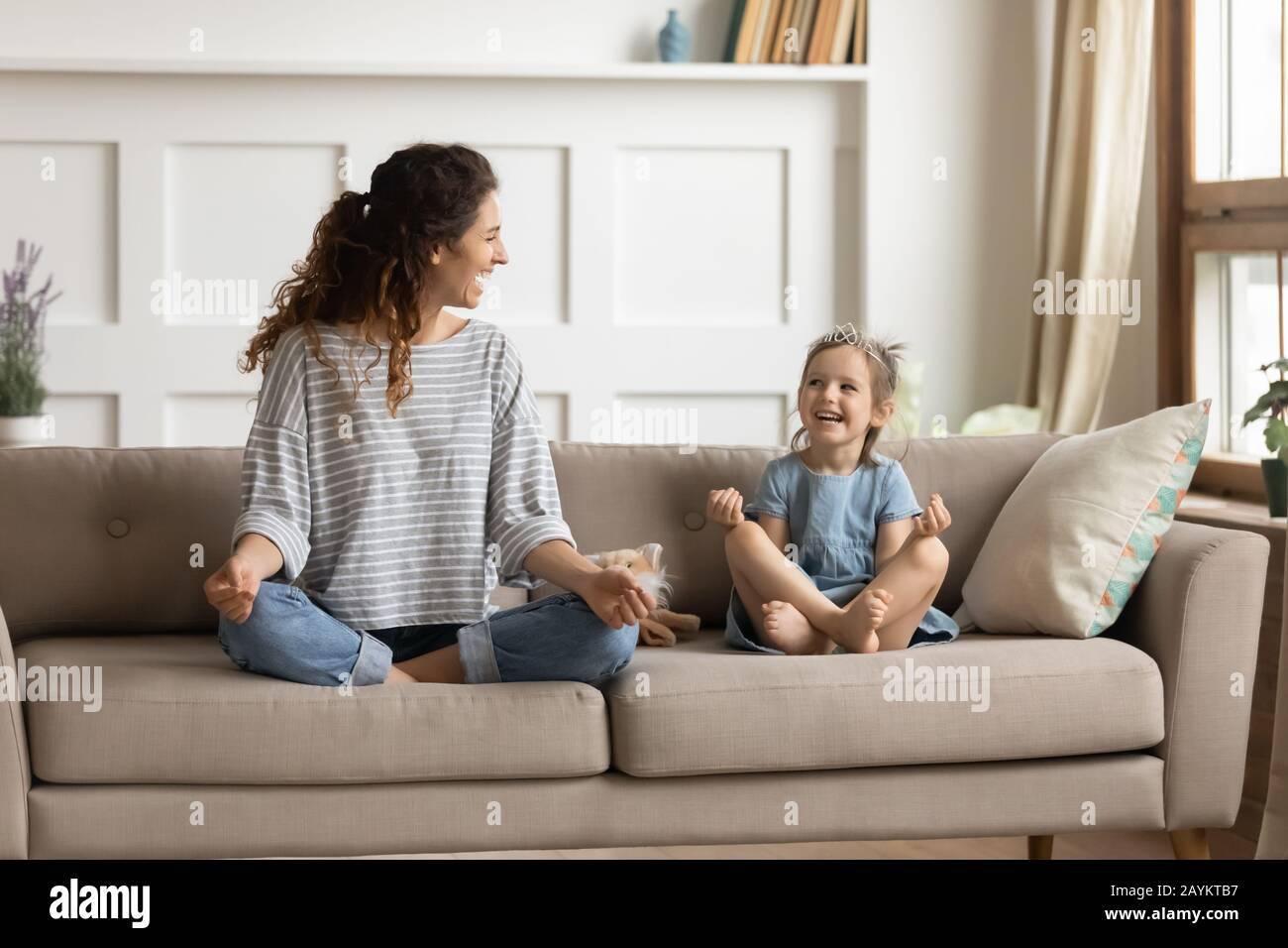 Happy mommy practicing yoga exercised with small child. Stock Photo