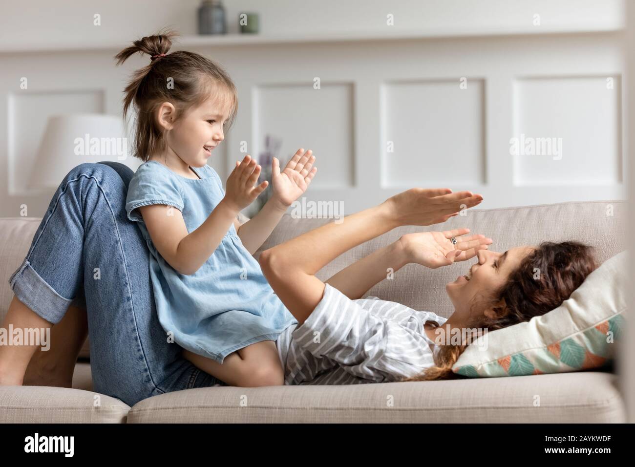 Happy little preschool girl playing patty cake with mom Stock Photo Alamy