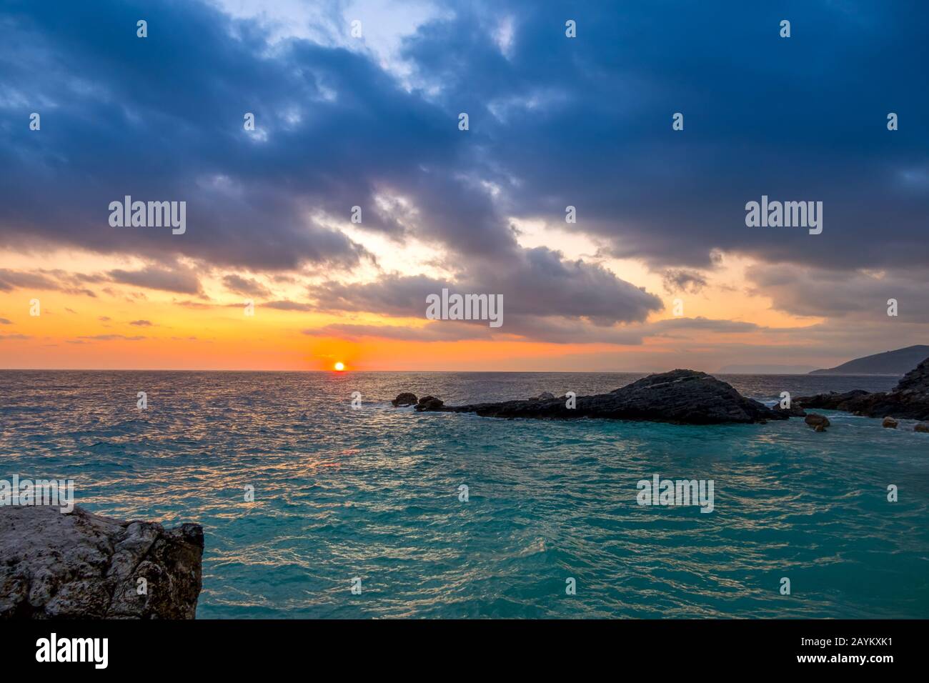 Rocky seashore. A lot of clouds in the sky and sun dawn Stock Photo
