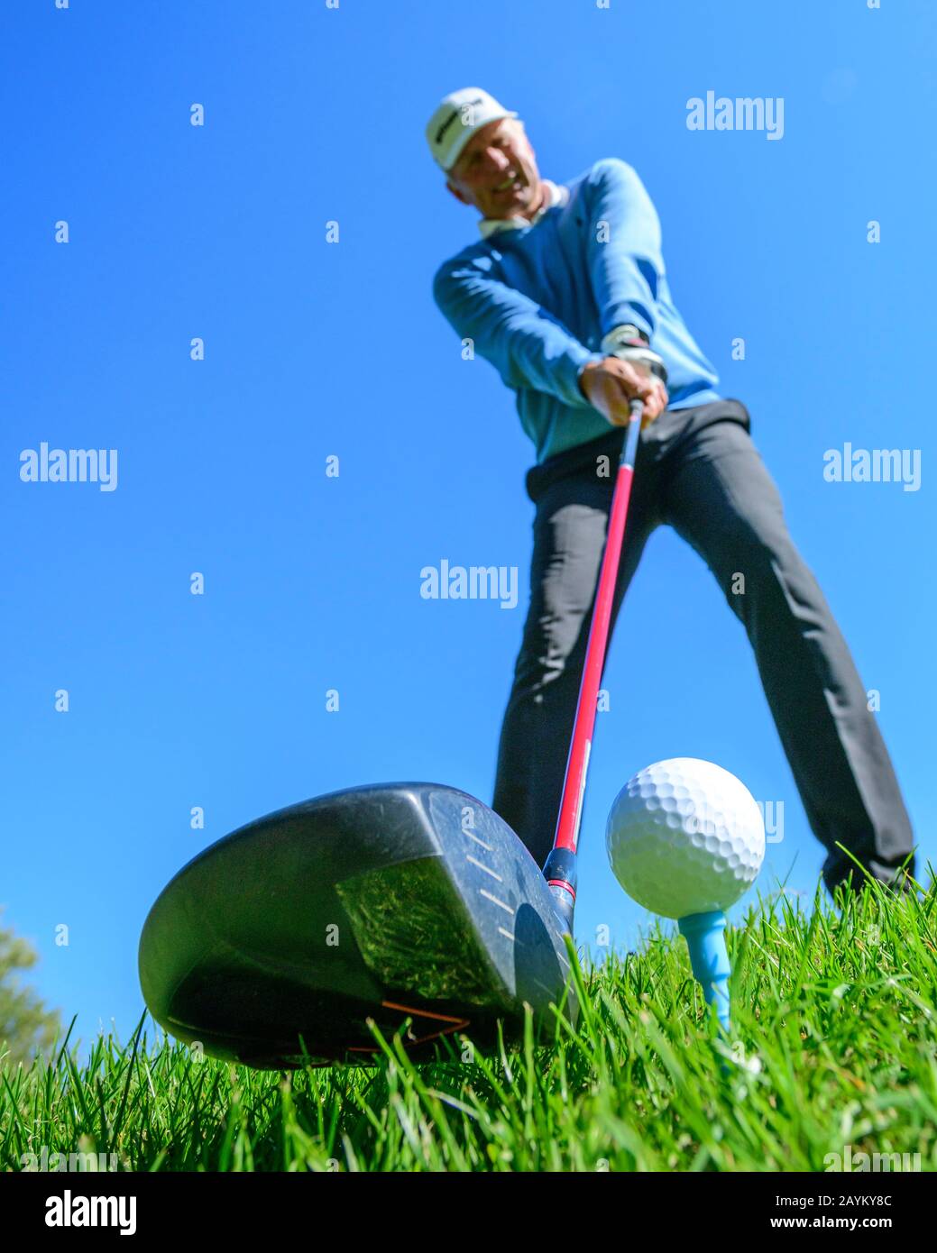 Golf player hitting a ball with driver Stock Photo