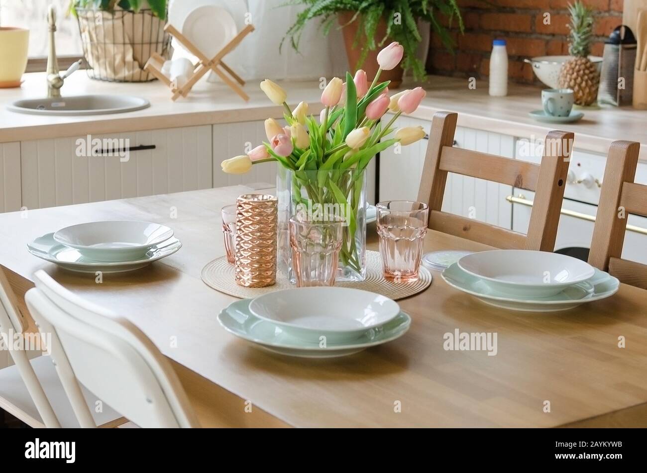 Stylish kitchen interior setting. Modern dining table setting with vase of  flower Stock Photo - Alamy