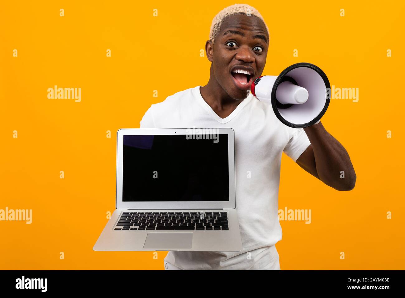 Download African Black Man With Megaphone And Laptop With Mockup On Yellow Studio Background Stock Photo Alamy