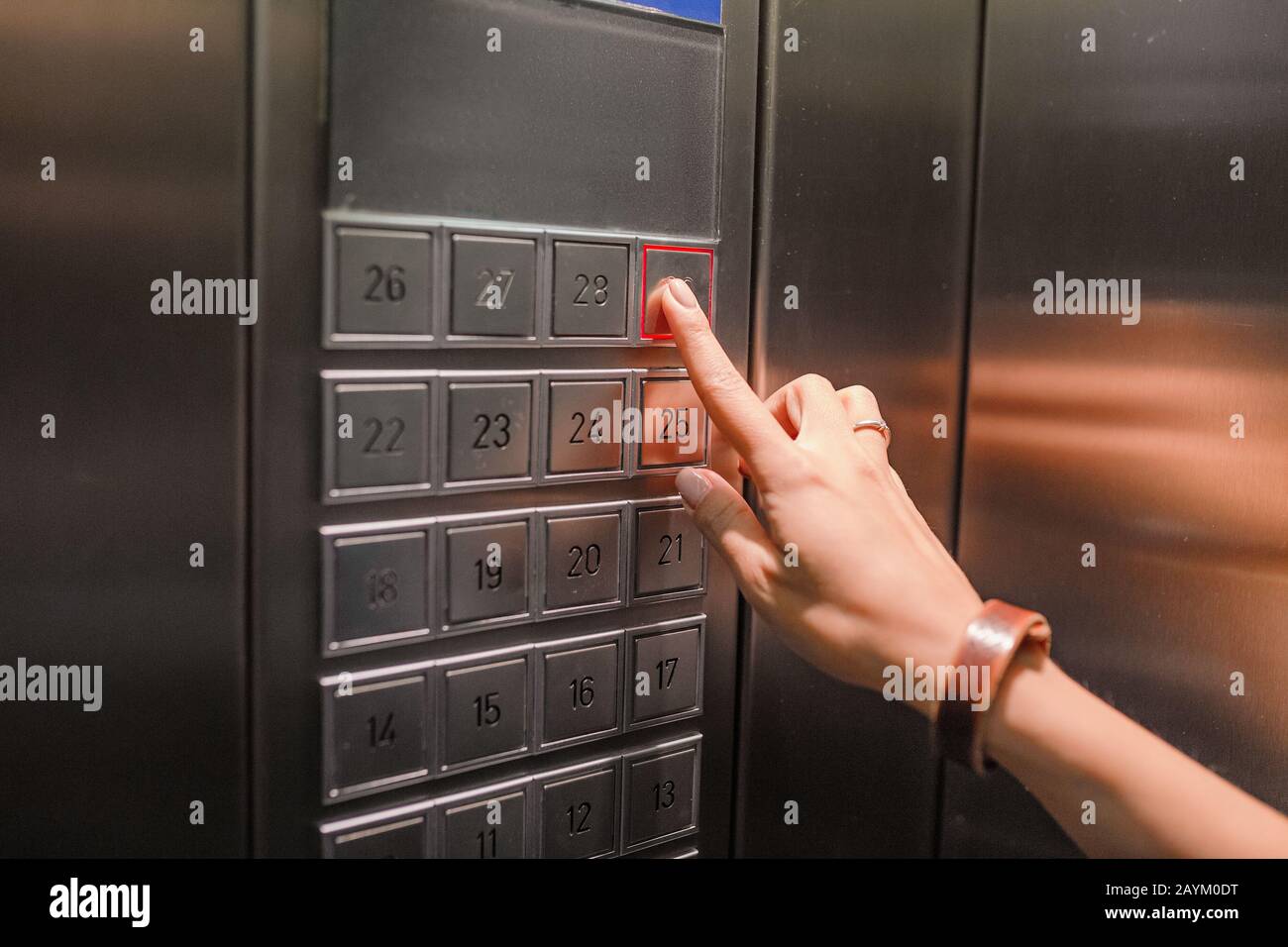 The hand presses on the elevator lift button Stock Photo