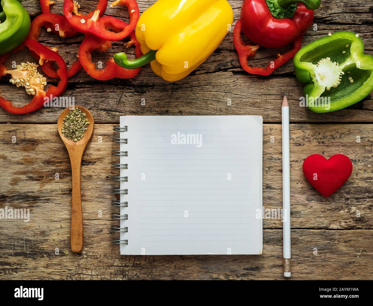 flat lay of blank recipe cooking book and utensils with herbs and colorful bell pepper over wooden background. top view with copy space. food recipe a Stock Photo