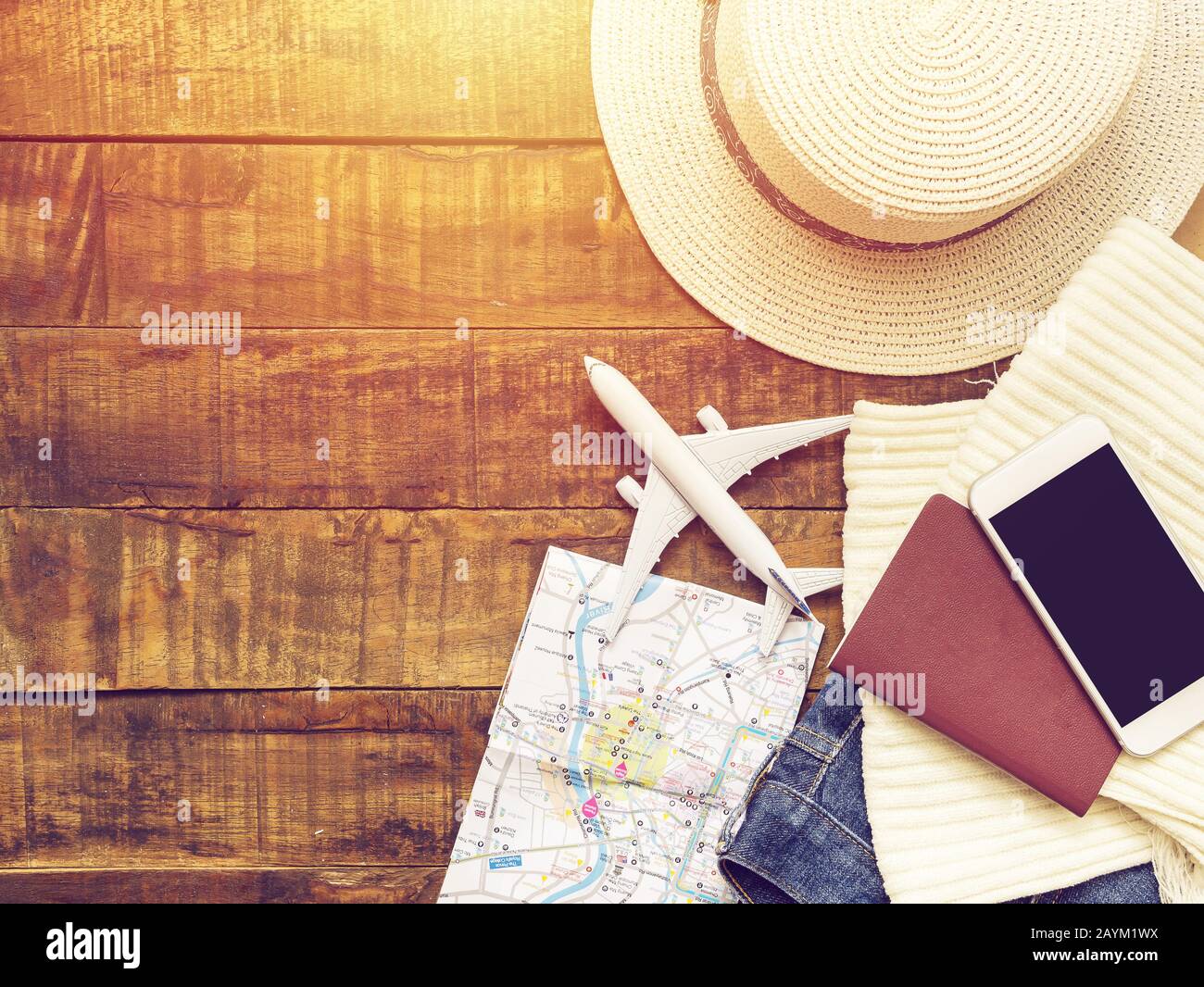 flat lay of passport , white plane model , map and traveler's accessories items on wooden background with copy space. travel and vacation concept Stock Photo