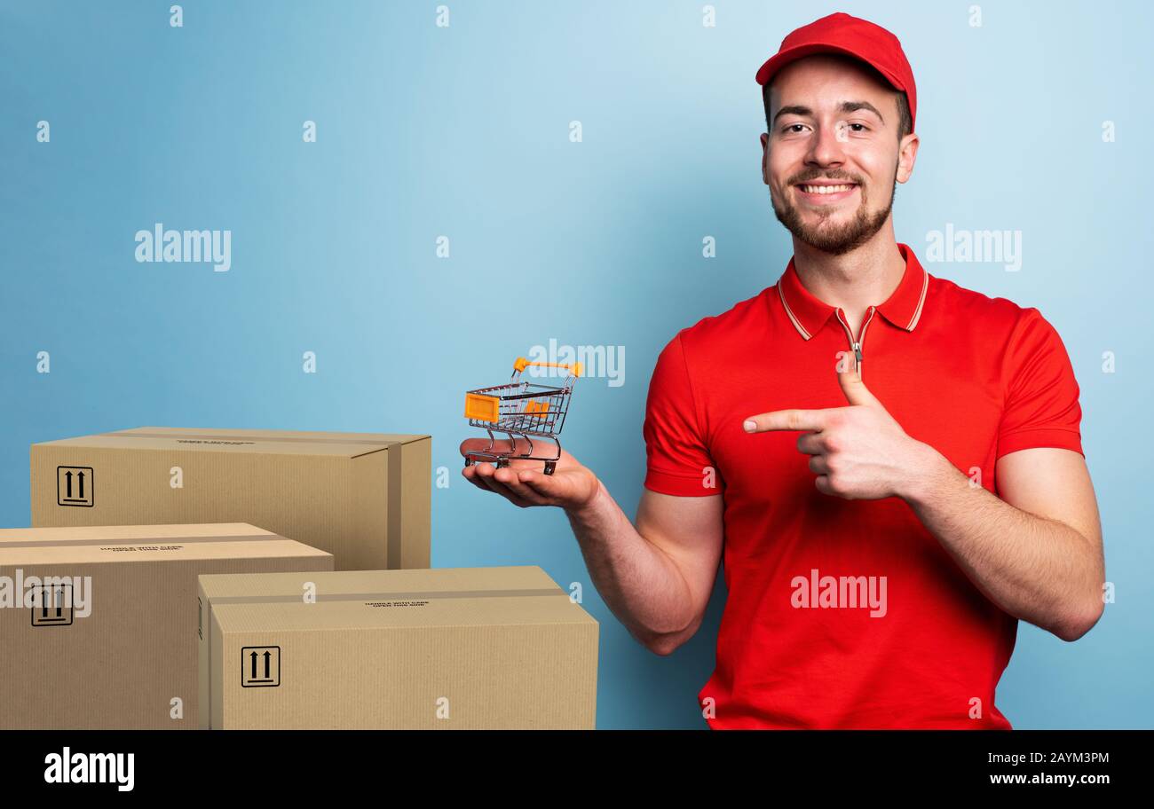 Courier has a small cart in hand. Concept of online shop. Emotional expression. Cyan background Stock Photo