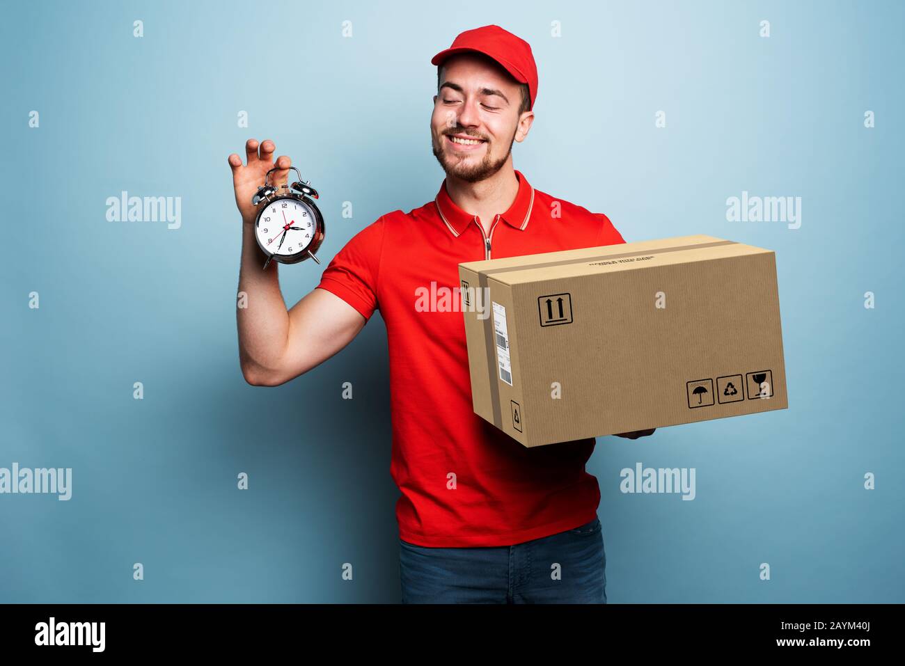 Courier is punctual to deliver the package. Emotional expression. Cyan background Stock Photo