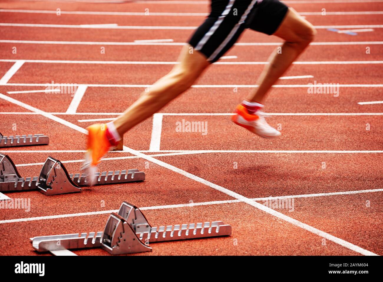Sports man start running on the stadium track sprint Stock Photo