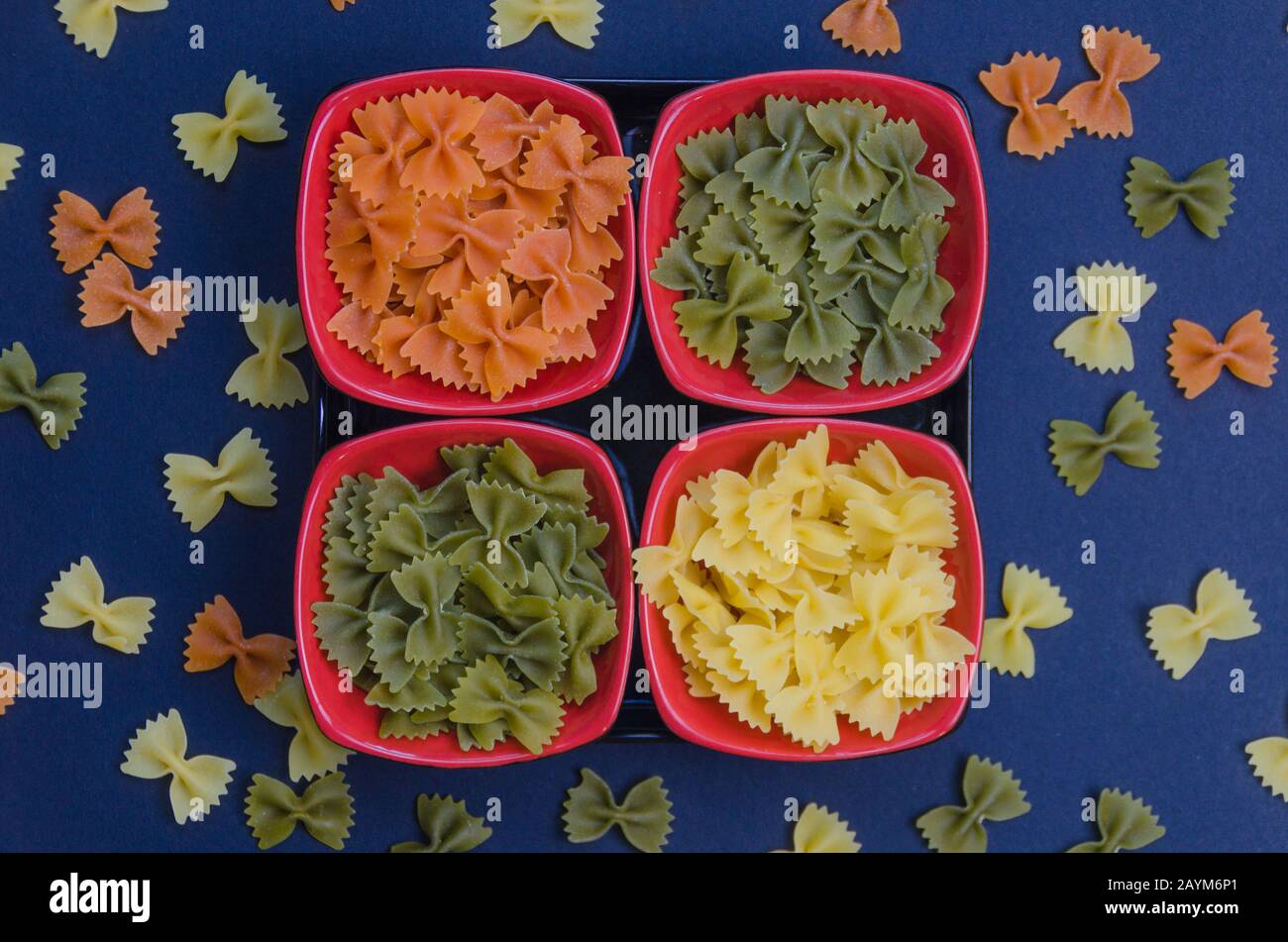 Four bowls filled with italian pasta on a blue background Stock Photo