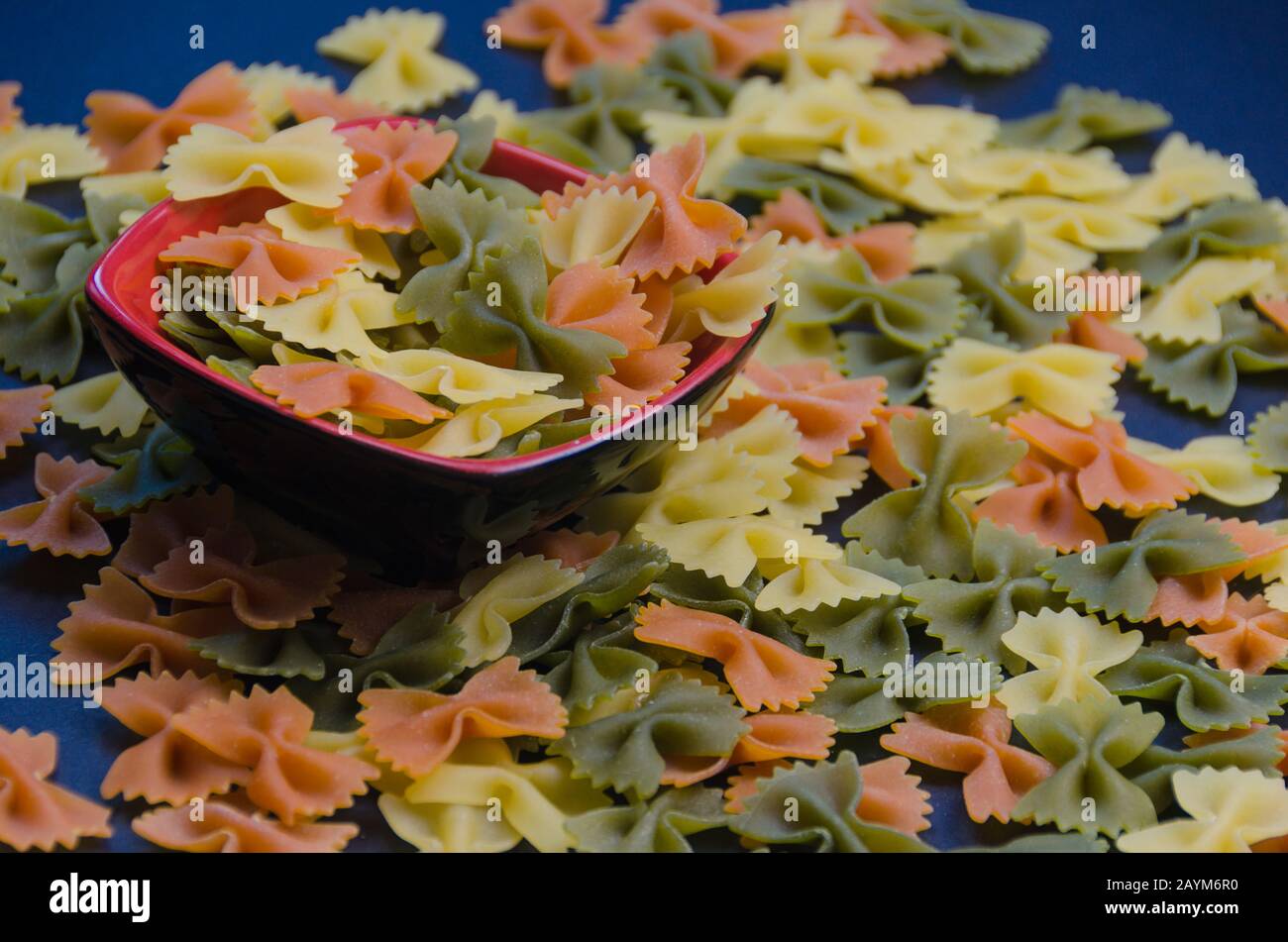 Pile of multicolored bow tie pasta on a blue background Stock Photo