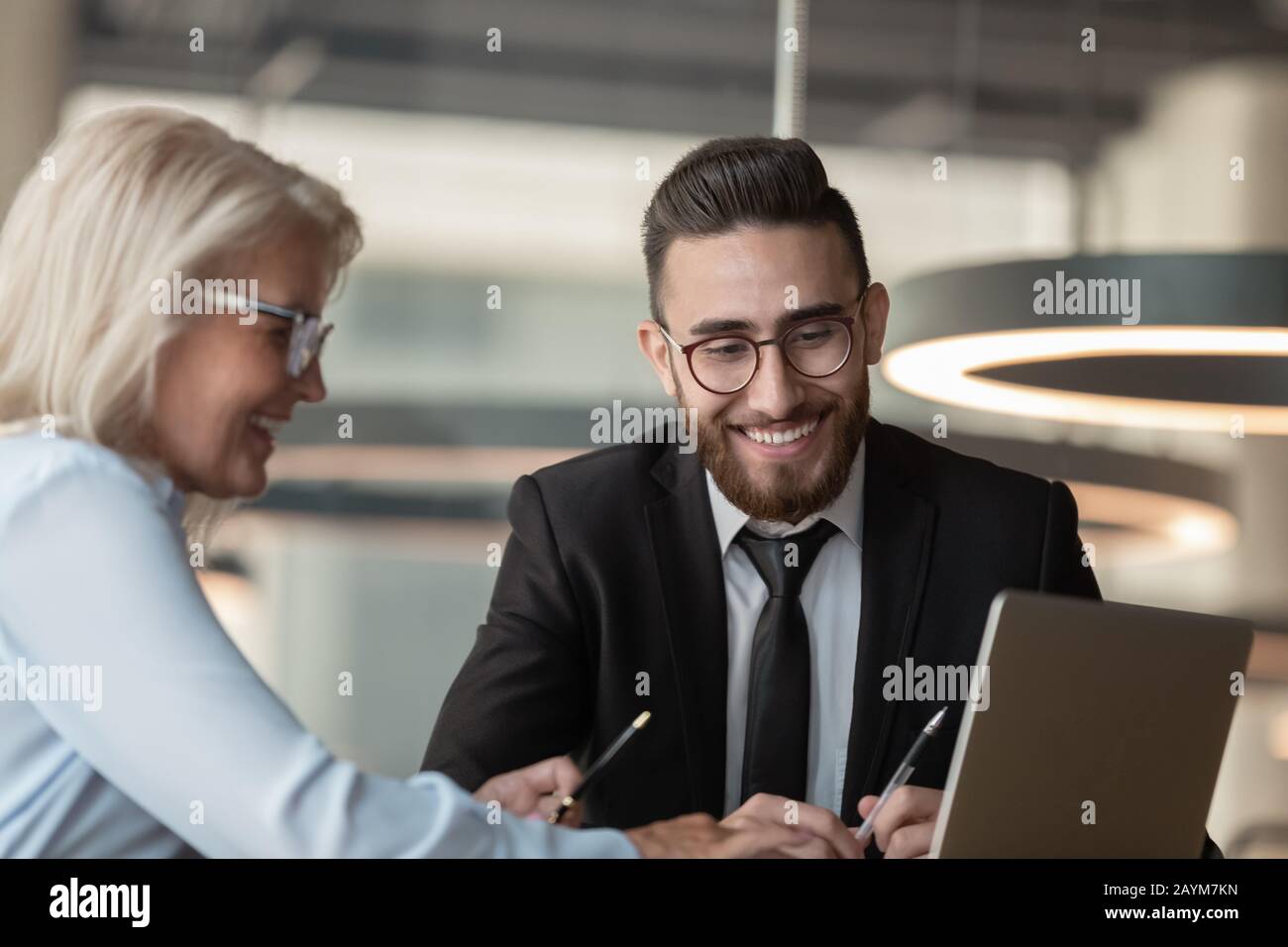European manager consulting arabian client using computer process provide information Stock Photo
