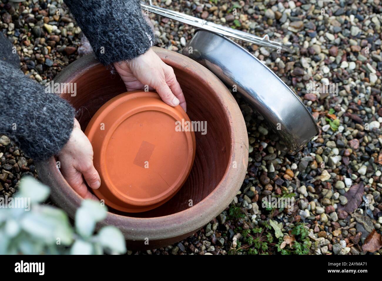 frost-free drinking trough, made of flower pot, saucer, grave candle, cooling rack and fireproof bowl, Germany Stock Photo